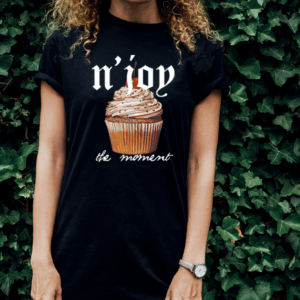 Person wearing a black T-shirt with a cupcake and text design.