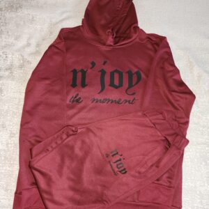 Red hoodie with black text design laid on a white surface.