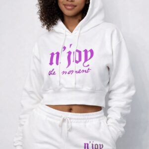 A woman wearing a white cropped hoodie with purple text.